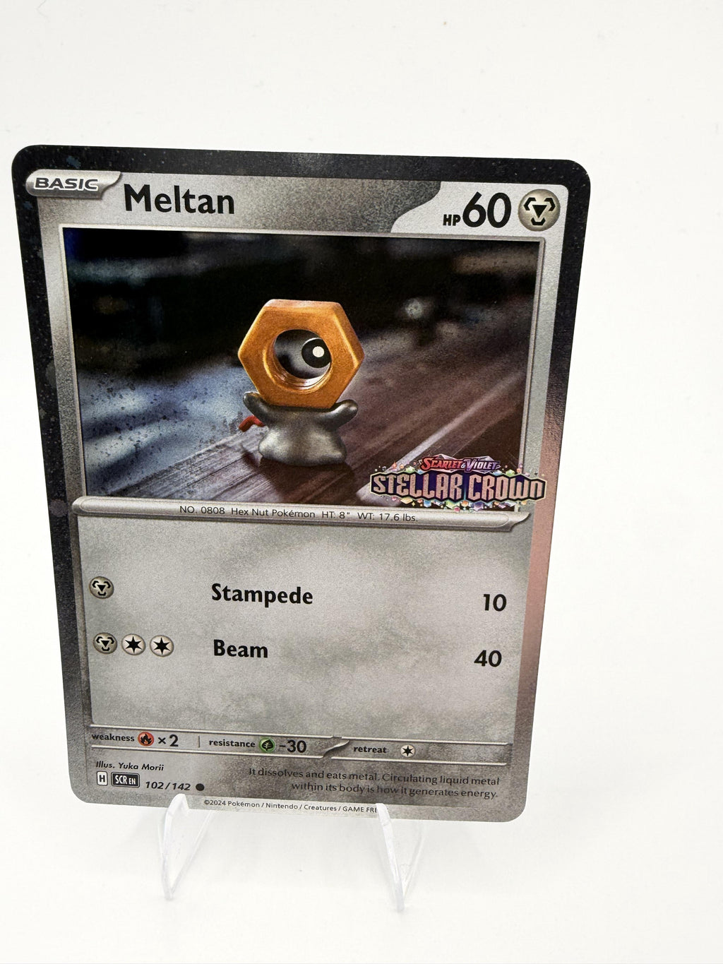 Meltan 102/142 Stellar Crown Cosmos Holo Pokemon 2024 Promo NM